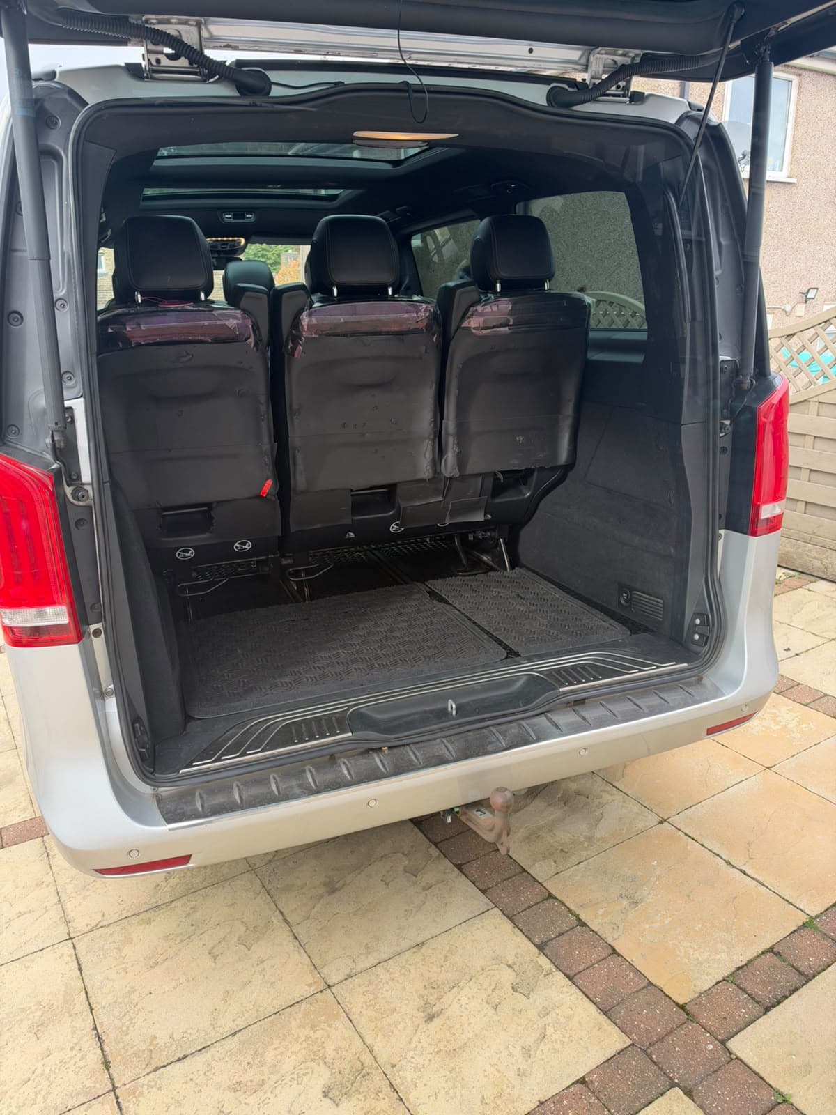 Open rear tailgate showing the luggage compartment behind passenger seats