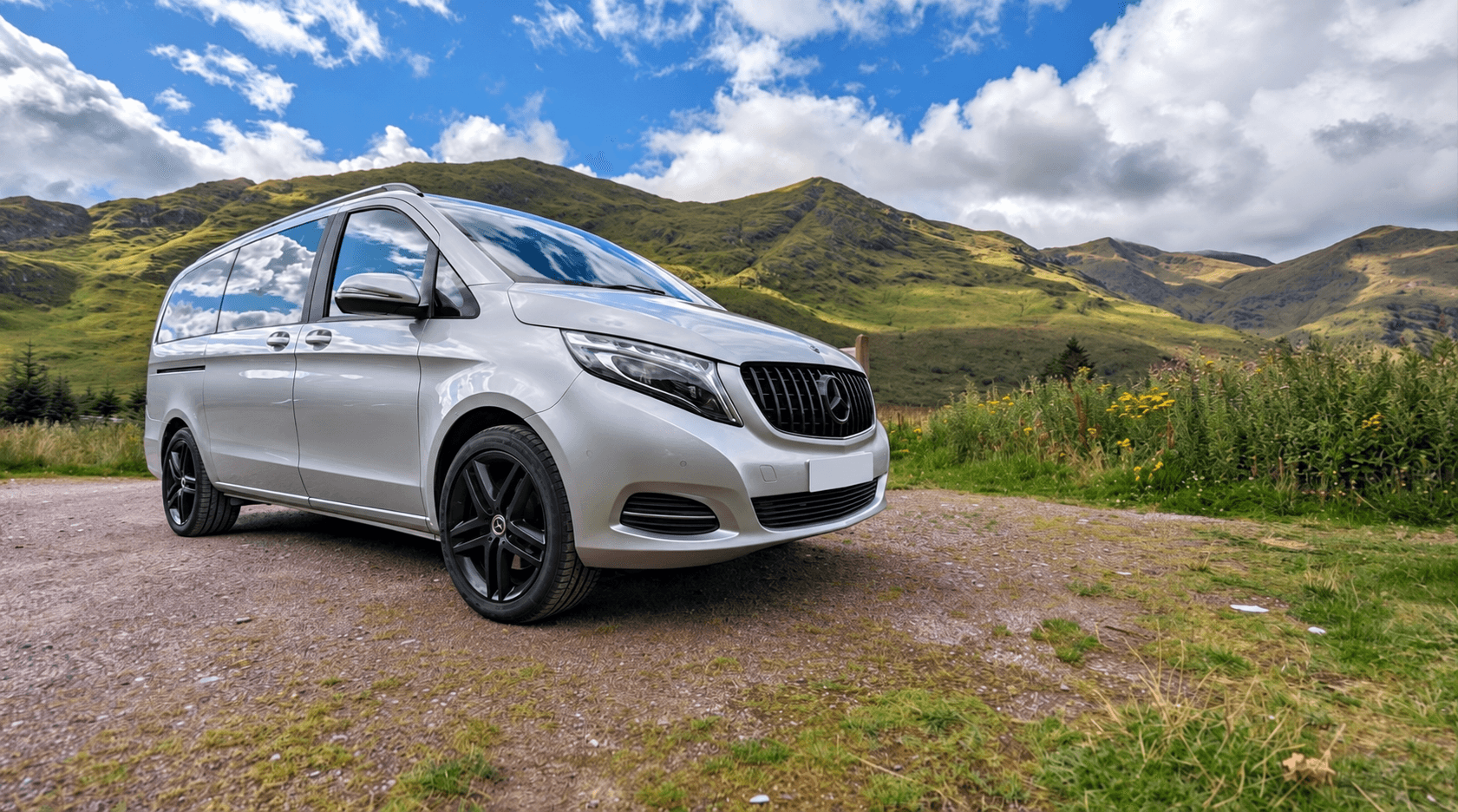 Mercedes-Benz vehicle photographed beside green hills